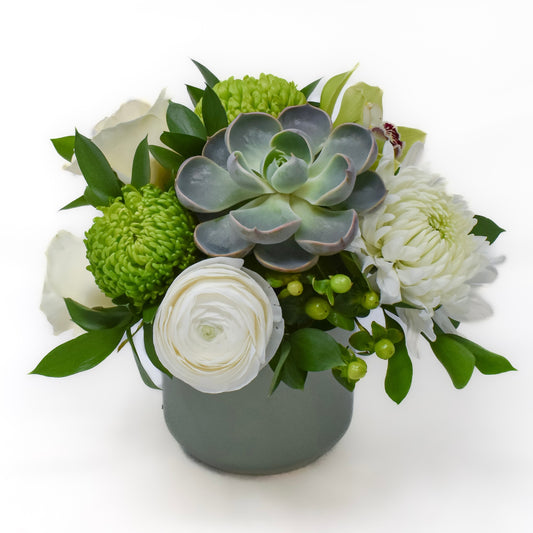Soft white and soft green flowers arranged in a sage green ceramic pot