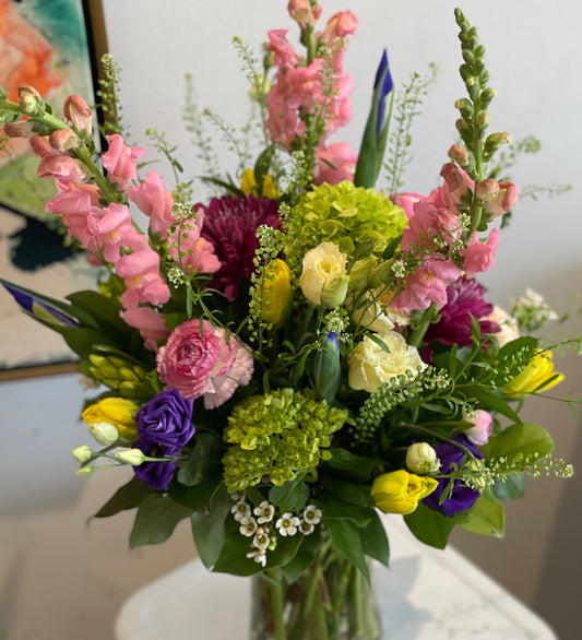 Spring flowers arranged in a tall glass vase