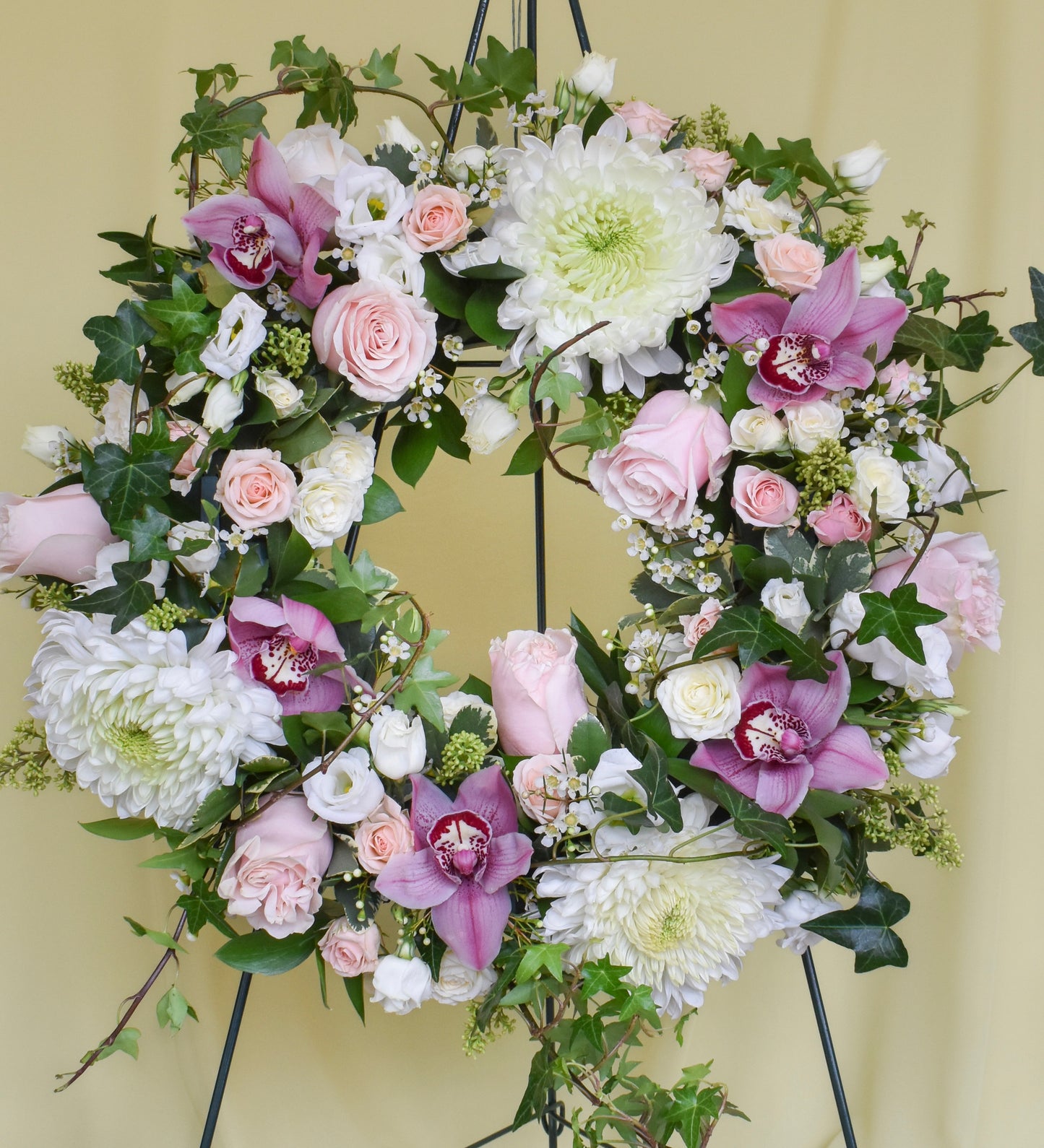 Sympathy wreath with white and light pink flowers and greens