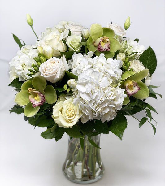 White and green flowers arranged in a tall vase