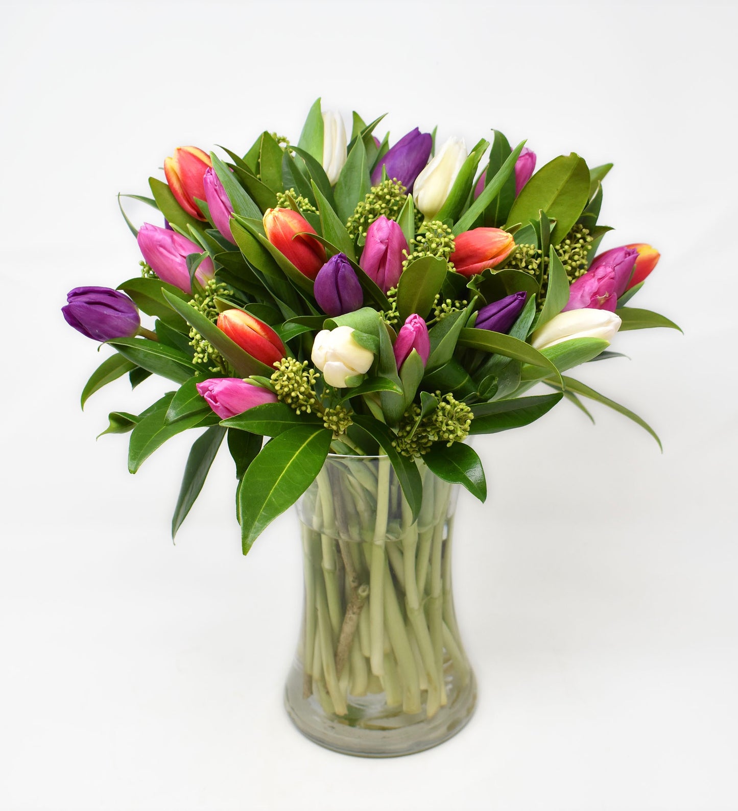 Brightly coloured tulips in a tall vase
