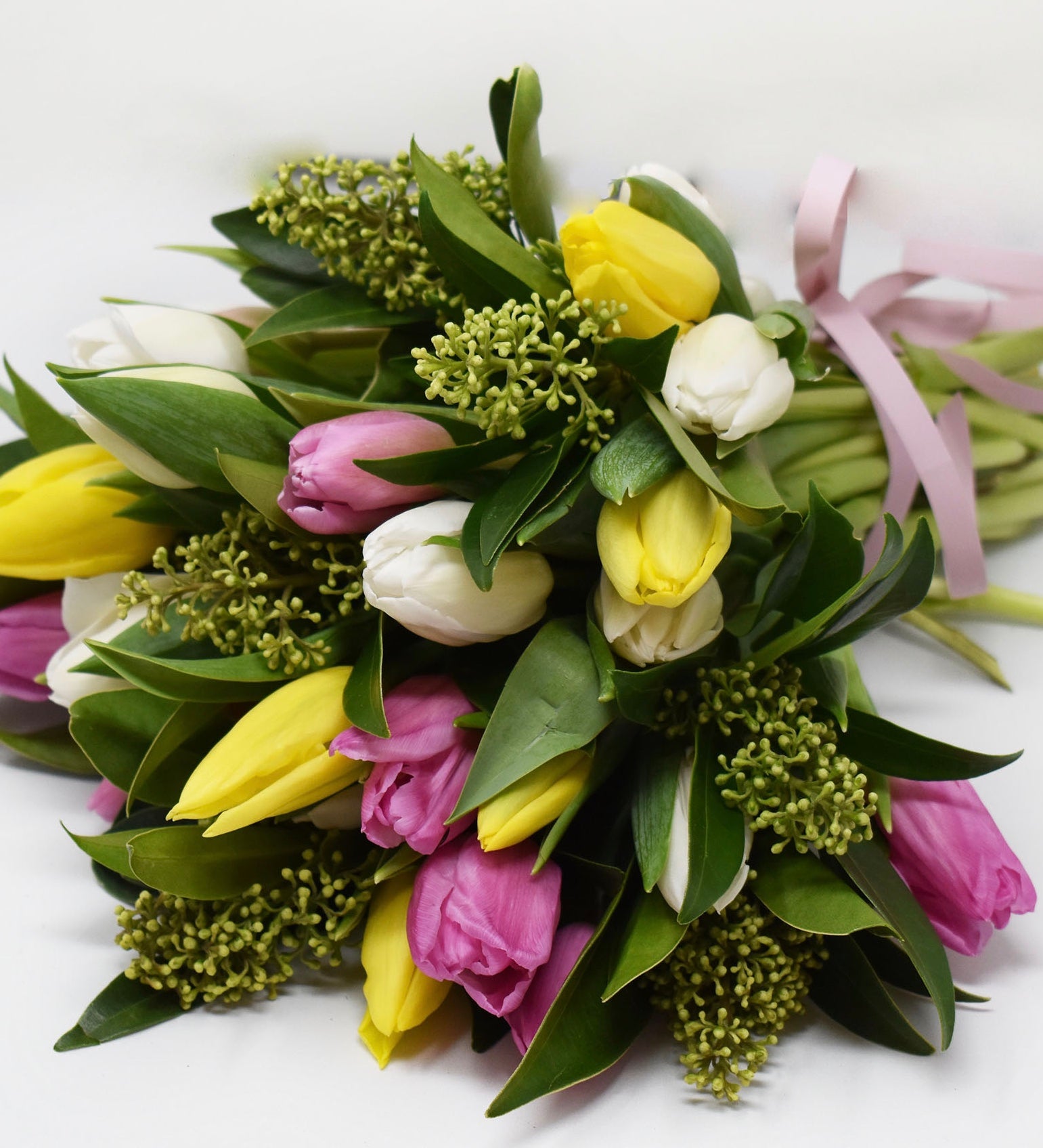 Pastel coloured tulips with greens in a bouquet